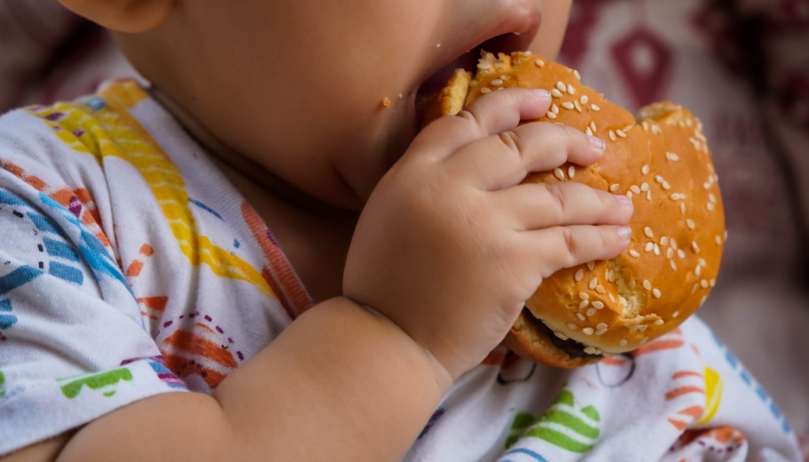 bambino che mangia l'hamburger